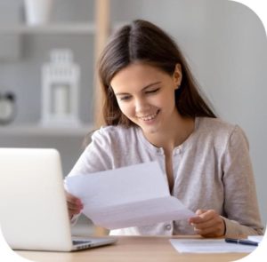 Woman smiling while reading letter — Your Trusted Accountant on the Central Coast, NSW